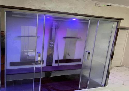 un ascenseur en verre dans un immeuble avec des lumières violettes dans l'établissement Hotel Holiday, à Foggia