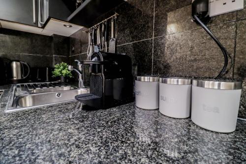 a kitchen counter with three trash cans on it at Spacious 4-Bed in St.John's Wood in London