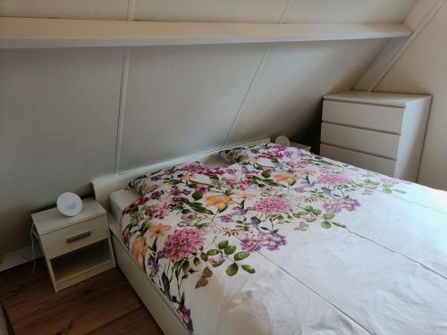 a small bedroom with a bed with a floral bedspread at Molière in Rekem