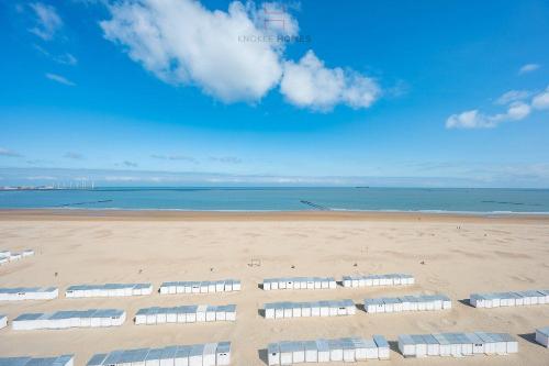 a beach with a bunch of beach chairs on it at Appartement 7 op de zeedijk in Knokke voor max 6 personen in Knokke-Heist