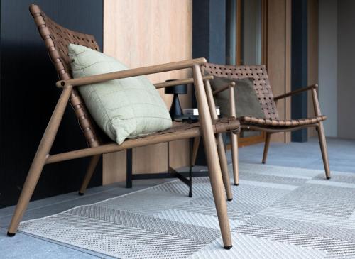 a wooden rocking chair with a white pillow on it at Laguna Beskidów Resort, Jezioro Żywieckie in Bierna