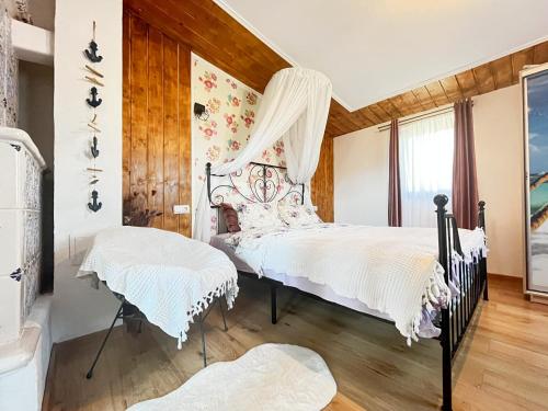 a bedroom with two beds and a window at Casuta de sub stanca Apuseni,hot tub inclus in Bîrdeşti
