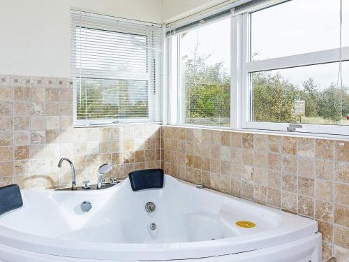 - Baño con bañera y 2 ventanas en 10 person holiday home in Brovst, en Brovst