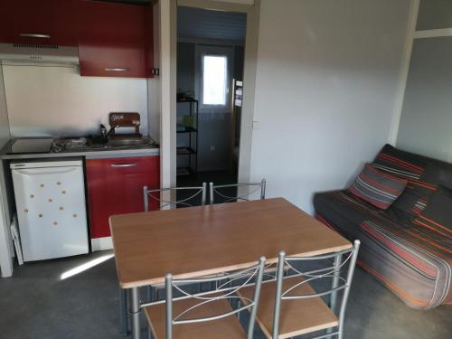 a small kitchen with a table and a couch at CHALET LOU PADER in Vézac