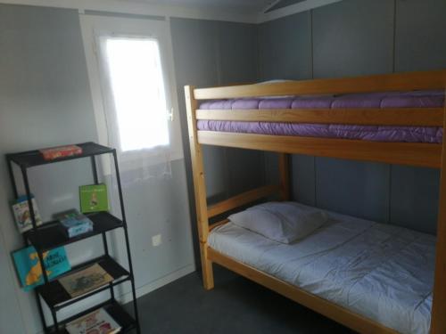 a bedroom with two bunk beds and a window at CHALET LOU PADER in Vézac