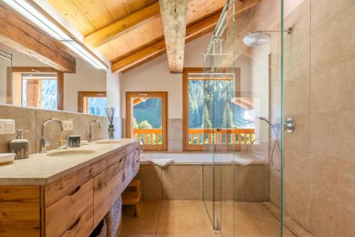 La salle de bains est pourvue d'une douche, d'un lavabo et d'une baignoire. dans l'établissement Chalet le 4 - 13 personnes, au Grand-Bornand