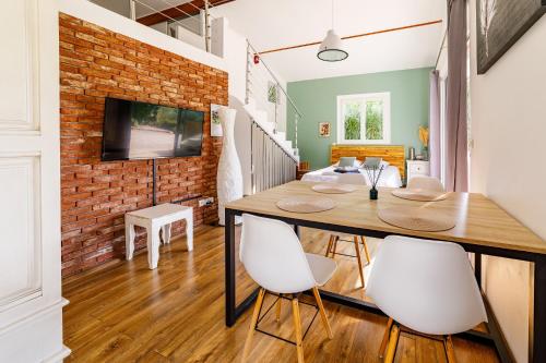 a dining room with a brick wall and a table and chairs at O PATIO DU MAS in Callas