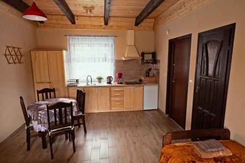 a kitchen with a table and a dining room at Apartamenty - Grądzkie 19 in Grądzkie