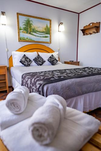 a hotel room with two beds with towels on them at Hostal Alcázar in Puerto Natales