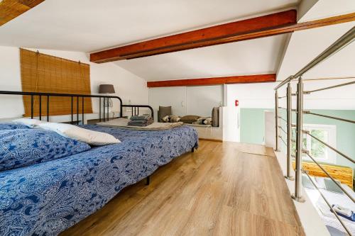 a bedroom with two beds and a wooden floor at O PATIO DU MAS in Callas