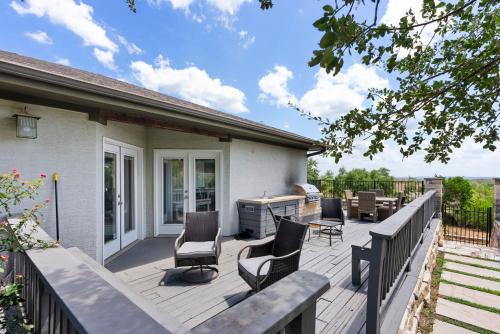 a deck with chairs and a grill on a house at Brand New Lake Travis Estate - Awesome Pool in Austin