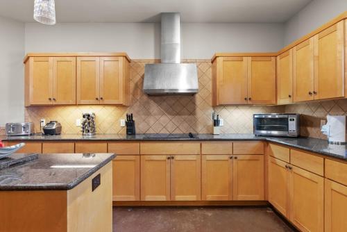 a kitchen with wooden cabinets and a microwave at Brand New Lake Travis Estate - Awesome Pool in Austin