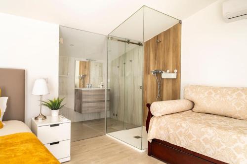 1 dormitorio con ducha, 1 cama y baño en Beach, Ocean view & Bright House Ericeira en Ericeira
