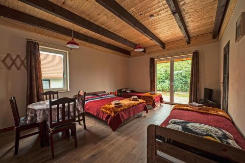 a bedroom with two beds and a table and chairs at Apartamenty - Grądzkie 19 in Grądzkie