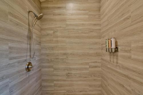 a bathroom with a shower with wooden tiles at A Cozy Cabin In The Country in Hawi