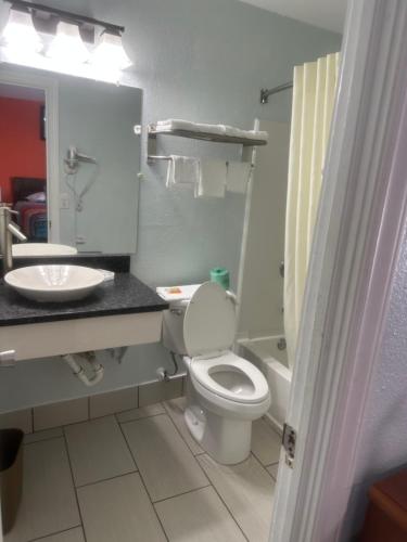 阿什維爾的住宿－Whispering Pines Motel，浴室配有白色卫生间和盥洗盆。