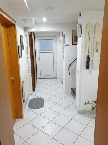 a hallway with a white tiled floor and a door at B & B Buchhorst 21481 in Buchhorst