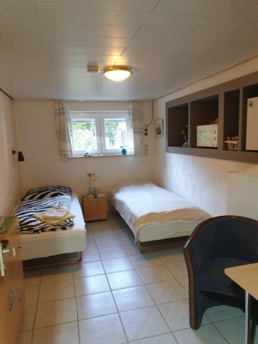 a bedroom with two beds and a table and a chair at B & B Buchhorst 21481 in Buchhorst