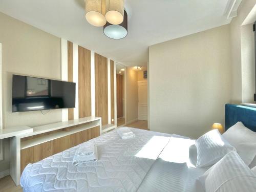a bedroom with a bed and a flat screen tv at Comfort Apartments Pasha in Budva