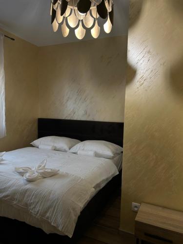a bedroom with a bed with white sheets and a chandelier at Villa Potôň 2023 in Horná Potôň