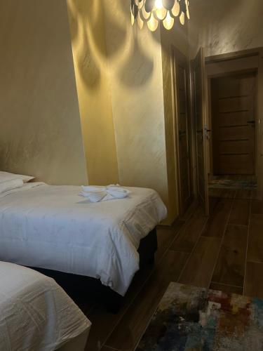 a hotel room with two beds and a chandelier at Villa Potôň 2023 in Horná Potôň