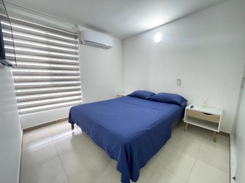 Un dormitorio con una cama azul y una ventana en TIM HOUSE, en Jamundí