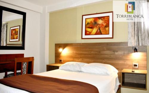 a bedroom with a bed with a wooden headboard at Torreblanca Hotel in Ilo