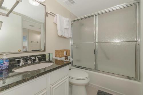 a bathroom with a shower and a toilet and a sink at Beachfront Madeira Norte in St Pete Beach