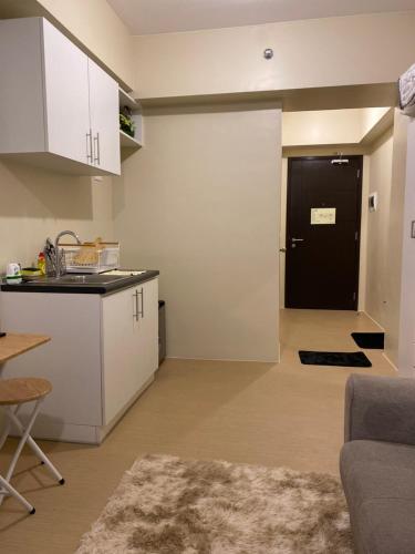伊洛伊洛的住宿－AVIDA ATRIA TOWER 3 Unit 3-320，一间厨房和带黑色门的客厅