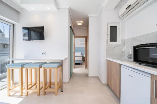 a kitchen with a bar with blue stools at Poseidon Deluxe Apartments in Kos