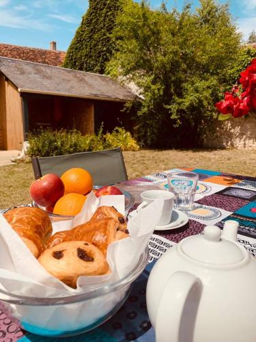 - une table avec un bol de pain et des fruits dans l'établissement Gîte des Quatre Lavoirs - 10' de Chambord, à Courbouzon