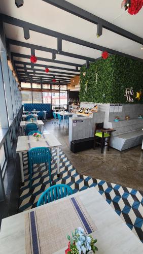 a restaurant with tables and blue chairs in a room at Hotel Roseliere Bucaramanga in Bucaramanga