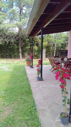 eine Terrasse mit Tischen und Blumen in einem Park in der Unterkunft La Colorada, home for... La Amistad Polo in Open Door