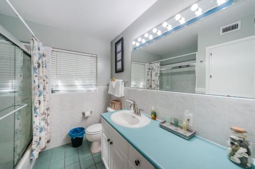 ein Badezimmer mit einem Waschbecken, einem Spiegel und einem WC in der Unterkunft Sea Breeze Beach House in Clearwater Beach