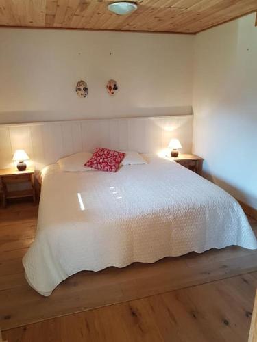 une chambre avec un lit blanc avec un oreiller rouge dans l'établissement Bethel-Mont-Blanc, à Saint-Gervais-les-Bains