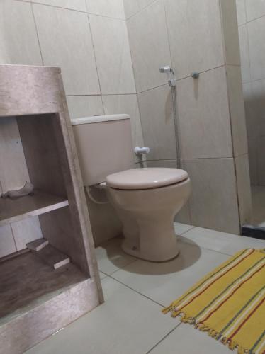 a bathroom with a toilet and a rug at Cantinho do Relax in Vera Cruz de Itaparica