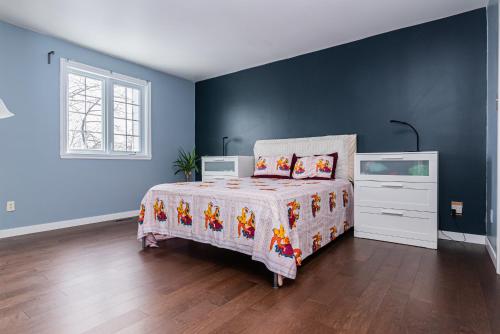 a bedroom with a bed and a dresser in it at Gorgeous 5 Bedroom House in Brossard