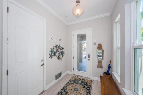 a hallway with a white door and a rug at Tranquil Tarpon Cottage in St Pete Beach