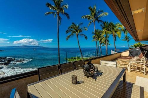 a table on a balcony with a view of the ocean at MAKENA SURF, #G-304 condo in Wailea