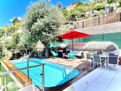 une piscine avec une table, des chaises et un parasol dans l'établissement Détente Côte d'azur, piscine et spa privatifs, à Menton