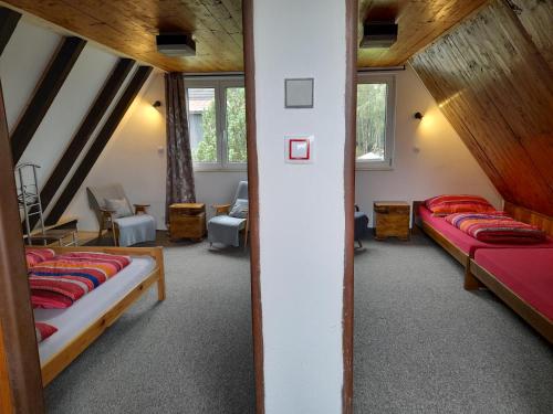 1 dormitorio con 2 camas en un ático en Chaloupka na vršku, en Loucná pod Klínovcem