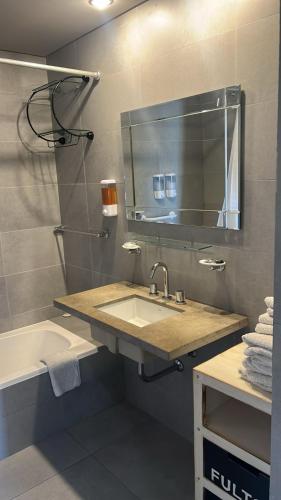 a bathroom with a sink and a mirror and a tub at Sissi Apart in Buenos Aires