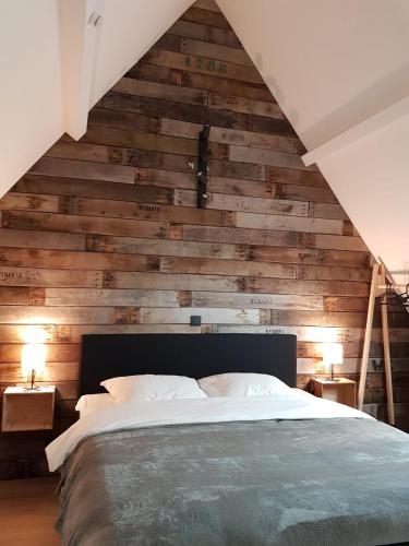 a bedroom with a wooden wall with a bed at Vakantiehuis Hanna in Zedelgem