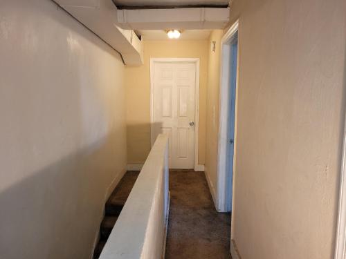 an empty hallway with a white wall and a white door at Downtown Norfolk private room D1 in Norfolk