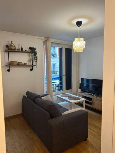 un salon avec un canapé et une télévision dans l'établissement Joli studio- quartier Montmartre, à Paris