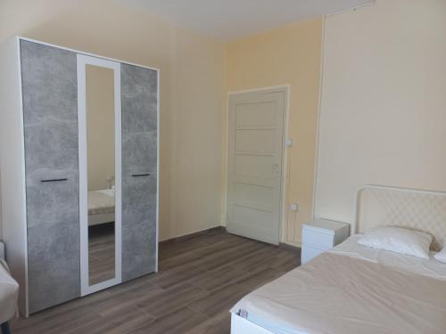 1 dormitorio con espejo junto a la cama en Веселый домик, en Lazarevo