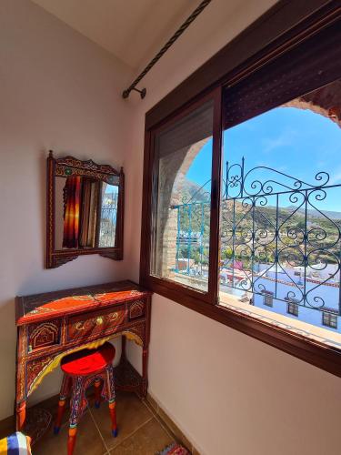 a room with a desk and a window with a view at Casa Blue Star in Chefchaouene