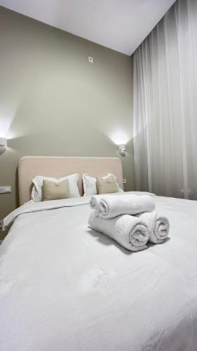 een slaapkamer met een wit bed en handdoeken bij Апартамент бизнес класса in Alma-Ata
