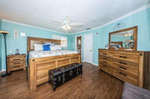 a bedroom with blue walls and a bed and a mirror at Sweet Escape Cottage in Clearwater Beach