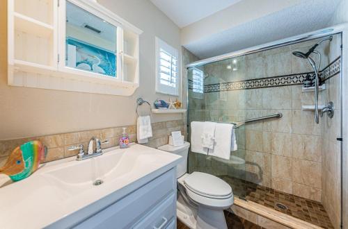 a bathroom with a sink and a toilet and a shower at Sweet Escape Cottage in Clearwater Beach